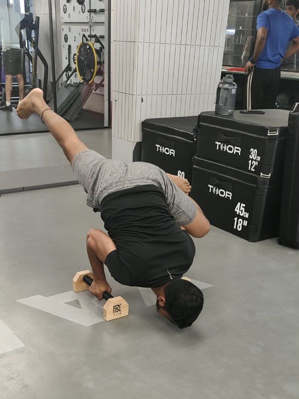 Student practising Arm balance on parallettes